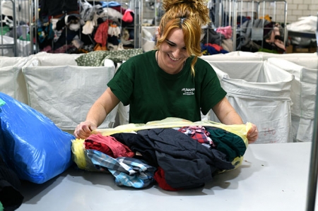 Una operaria de humana clasificando ropa (HUMANA FUDNACIÓN)