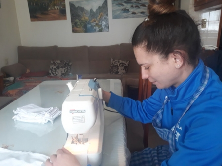 Una mujer confecciona una mascarilla (IU) 