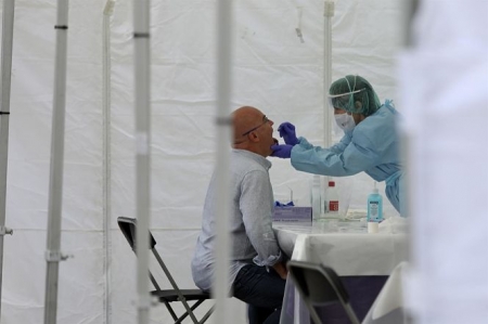 Una sanitaria realiza una frotis bucal (JAVI COLMENERO - EUROPA PRESS) 