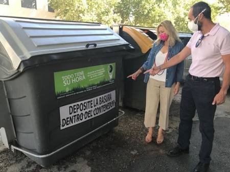 La concejal de Medio Ambiente, Pepa Rubia, señala uno de los adhesivos en un contenedor (AYTO. GRANADA) 