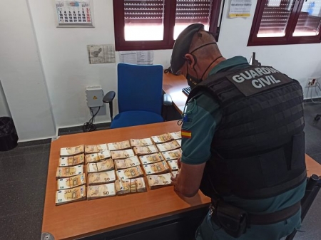 Un guardia civil con el dinero intervenido (GUARDIA CIVIL) 