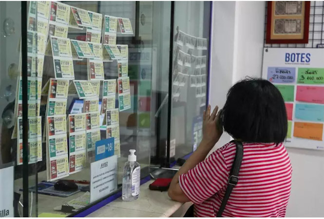 Una mujer compra lotería en una administración (IVÁN TERRÓN - EUROPA PRESS)