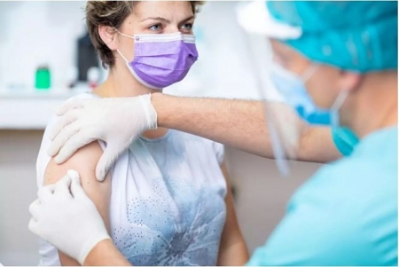 Mujer recibiendo la vacuna del covid (ZORANM/ISTOCK)