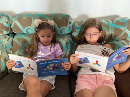 Dos alumnas de la residencia escolar `Virgen de los Remedios` de Montefrío leen el libro de relatos (AYTO. MONTEFRIO)