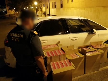 Agente con las cajetillas de tabaco incautadas (GUARDIA CIVIL :