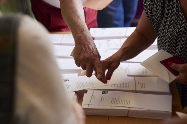 Varias personas cogen votos de una mesa electoral, en imagen de archivo (JOAQUÍN CORCHERO / EUROPA PRESS)