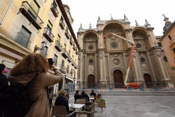 Varios operarios, subido a una grúa , revisan la fachada de la Catedral de Granada (ÁLEX CÁMARA / EUROPA PRESS)