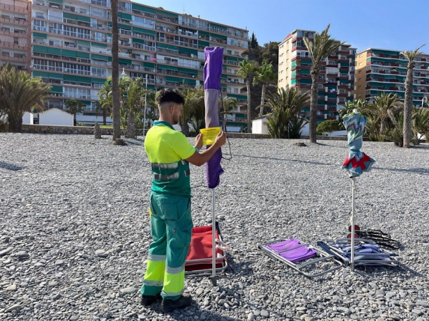 Imagen de archivo de un operario de Playas señalizando sombrillas en agosto de 2023 (AYUNTAMIENTO)