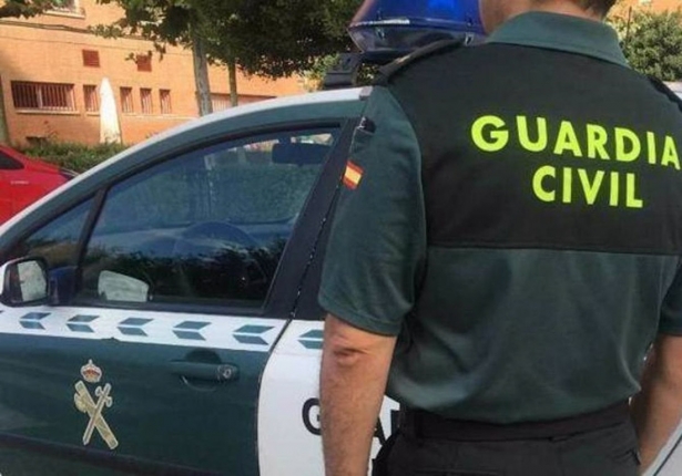 Imagen de archivo de un agente de la Guardia Civil ante un coche patrulla (GUARDIA CIVIL)