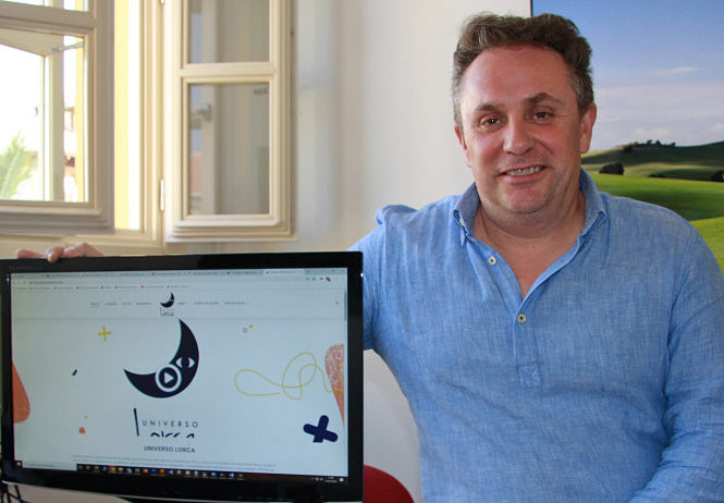 El diputado de turismo, Enrique Medina posa junto a la web (DIPGRA)