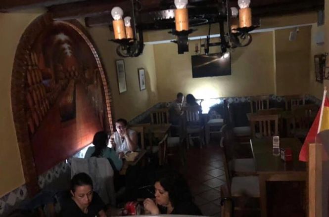 Clientes de un bar de Montefrío se alumbran con la linterna de su teléfono móvil durante uno de los cortes de luz producidos este fin de semana (AYTO. MONTEFRIO)