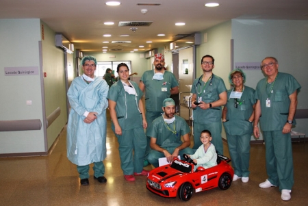 Equipo de cirugía con un niño en uno de los coches eléctricos (HUSC) 