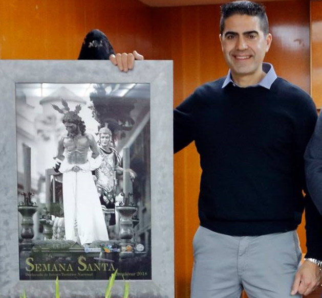 Leo Cervilla posa con el cartel (AYTO. ALMUÑÉCAR)