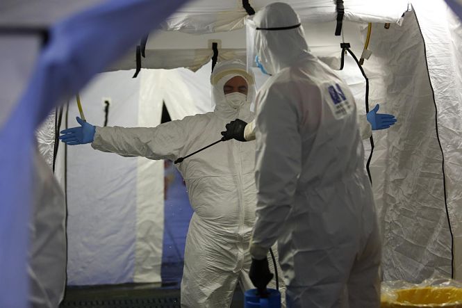 Trabajadores de proteccion civil se desinfectan contra el coronavirus en una carpa instalada en el hospital del PTS (ÁLEX CÁMARA / EUROPA PRESS) 