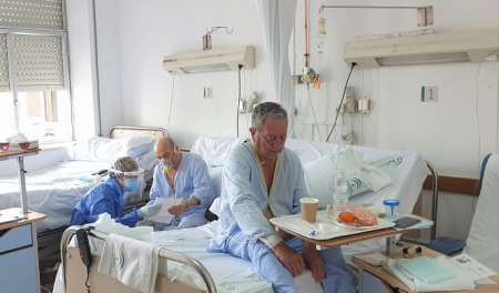 Una enfermera lee una carta a un paciente (HOSPITAL SAN CECILIO) 