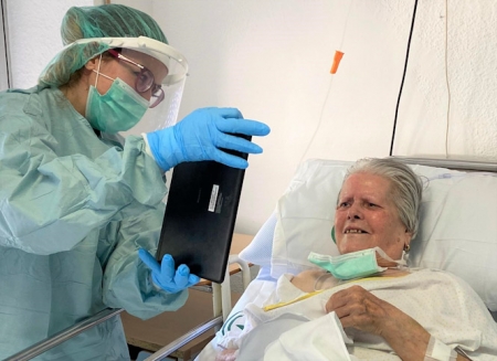 Un sanitario pone en contacto a una paciente con sus familiares a través de una tablet (HUSC) 