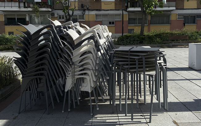 Sillas agolpadas en una terraza cerrada 