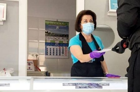 Una comerciante de la zona recibe la octavilla informativa (JUNTA)