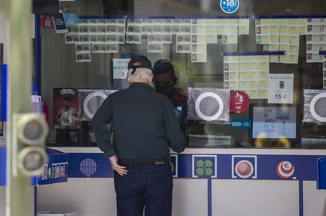 Un cliente compra lotería en una administración (MARÍA JOSÉ LÓPEZ / EUROPA PRESS)