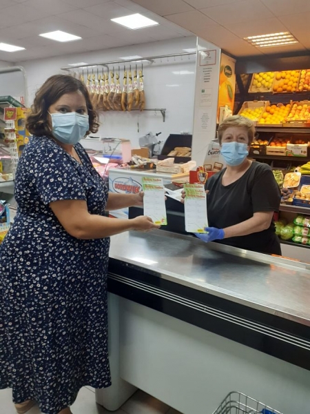 La concejala de Comercio de Vegas reparte las cartillas de esta campaña en un comercio del municipio (AYTO. VEGAS DEL GENIL)