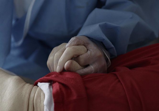 Una trabajadora de un Centro de Mayores sujeta la mano de un residente - EDUARDO PARRA / EUROPA PRESS)