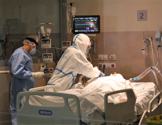 Un sanitario atiende a un paciente de la UCI (HUSC) 