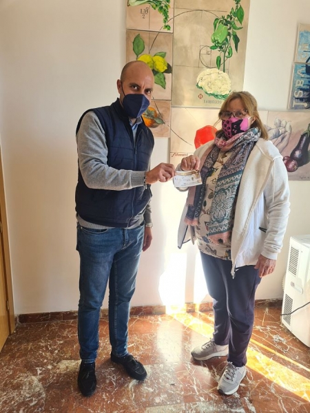 el alcalde de Otura. Nazario Montes, entrega su bono de compra a la primera vecina agraciada en el sorteo, Fátima Blanco (AYTO. OTURA) 