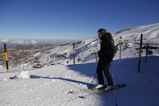 Esquiador con mascarilla en la estación de esquí de Sierra Nevada el primer día de apertura de la temporada invernal (ÁLEX CÁMARA / EUROPA PRESS)