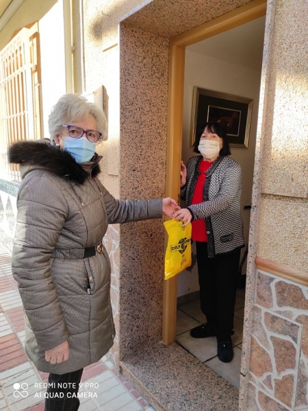una voluntaria entrega la compra a una vecina de Huétor Tájar en su domicilio (AYYO. HUÉTOR TAJAR)