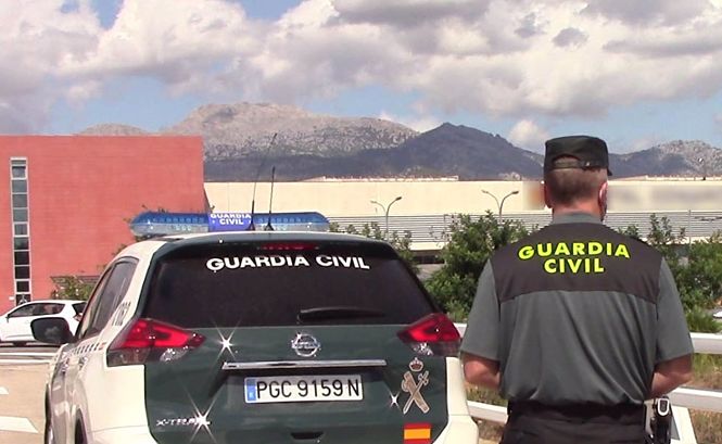 Un vehículo de la Guardia Civil y un agente de espaldas (GUARDIA CIVIL)