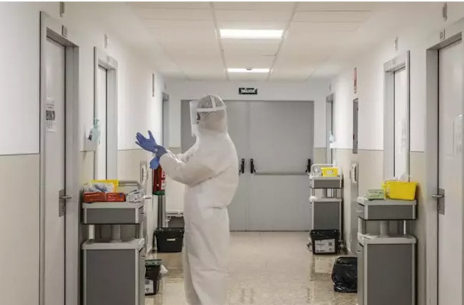 Un trabajador sanitario se dispone a entrar en una habitación (ROBER SOLSONA / EUROPA PRESS) 