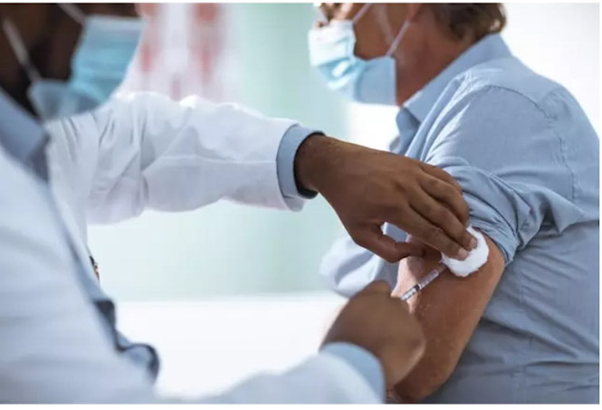 Un sanitario inyecta una vacuna (STOCK) 