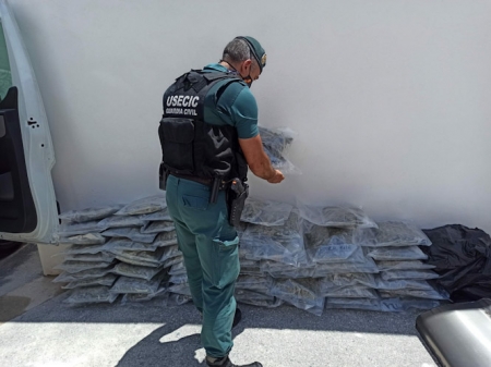 Un agente de la Guardia Civil junto a la marihuana incautada (GUARDIA CIVIL)