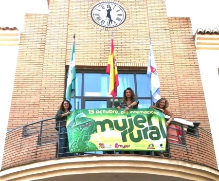 Mujeres colgando la pancarta del Día Internacional de la Mujer Rural en el Ayuntamiento (AYTO. VEGAS DEL GENIL) 