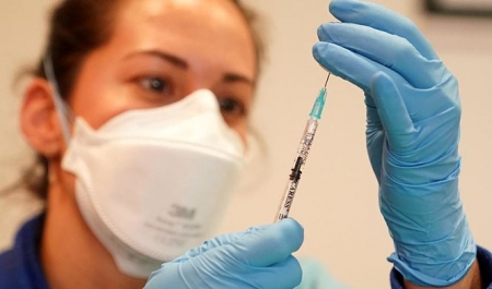 Una profesional sanitaria se dispone a administrar una vacuna.