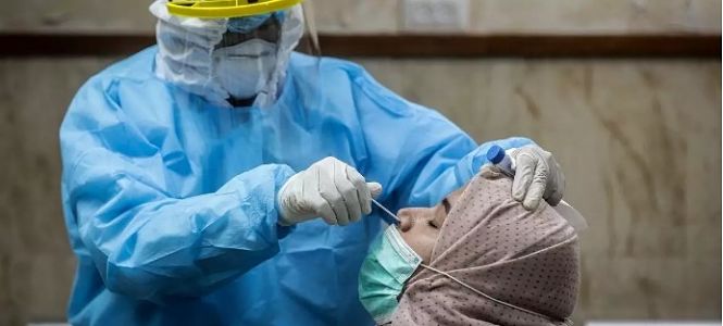 Un trabajador de salud hace la prueba de la COVID-19 a una mujer (NACIONES UNIDAS)