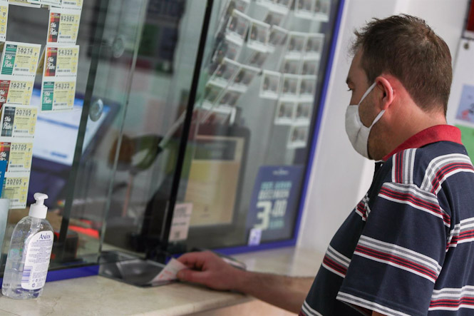 Un hombre compra lotería en una administración (IVÁN TERRÓN - EUROPA PRESS)