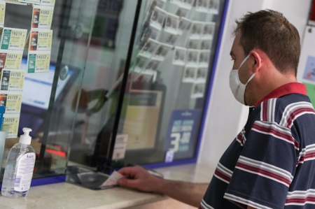 Un hombre compra lotería en una administración (IVÁN TERRÓN - EUROPA PRESS)