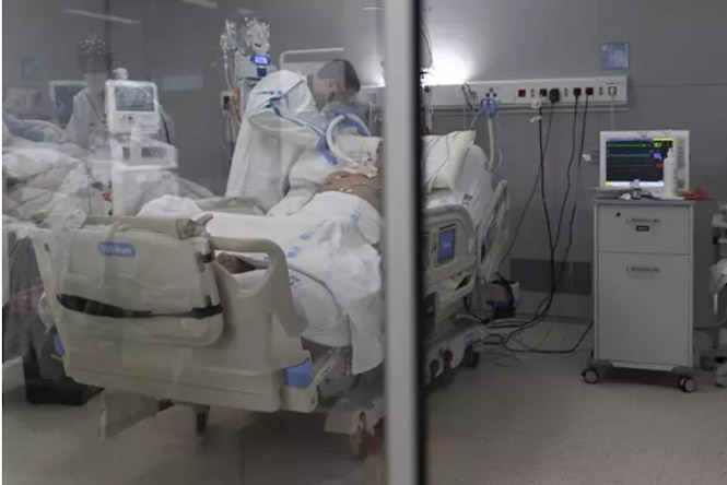Un sanitario alrededor de un paciente ingresado en la UCI (EDUARDO PARRA / EUROPA PRESS) 