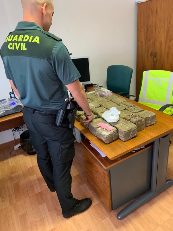 Un agente de la Guardia CIvil con la droga incautada (GUARDIA CIVIL)