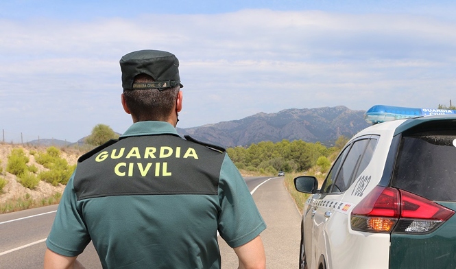 Un agente de la Guardia Civil junto a un vehículo en una carretera. (GUARDIA CIVIL) 