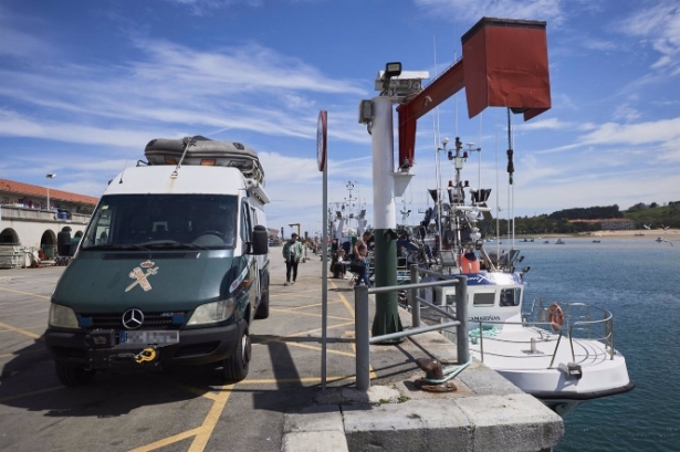 Un furgón de la Guardia Civil al lado de un barco (CÉSAR ORTIZ - EUROPA PRESS) 