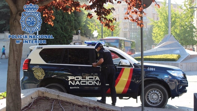 Agente de la Policía Nacional junto a un vehículo policial. Archivo (POLICÍA NACIONAL)