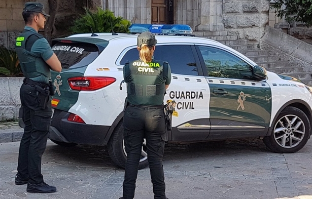 Dos agentes de la Guardia Civil junto a un coche oficial, en imagen de archivo (GUARDIA CIVIL)