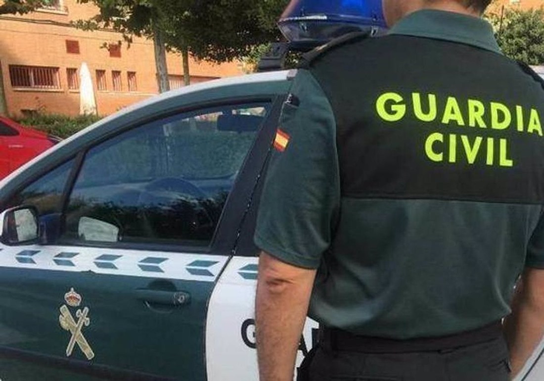 Imagen de archivo de un agente de la Guardia Civil ante un coche patrulla (GUARDIA CIVIL)