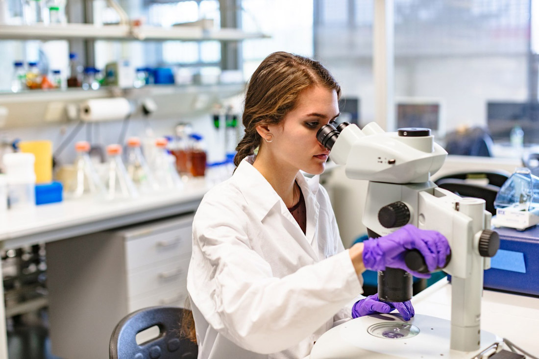 Una científica observando a través de un microscopio. Imagen de archivo (PAUL GULEA)