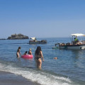 Un barco limpia una playa de Almuñécar (AYTO. ALMIñÉCAR)