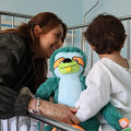 Una mama con su pequeña abrazan a Quiro antes de una intervención.