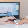 Concepto de diagnóstico de esclerosis sistémica: se aprecian las manos de un médico y un paciente junto con la maquinaria de diagnóstico (CESARE FERRARI)
