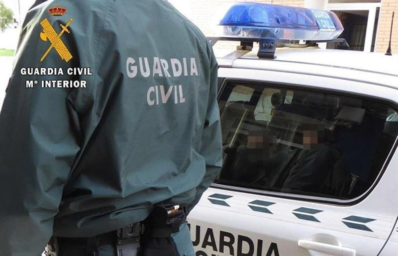 Un agente de la Guardia Civil junto a un coche patrulla (GUARDIA CIVIL) Un agente de la Guardia Civil junto a un coche patrulla (GUARDIA CIVIL)